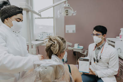 Dr. Talluri and an Exquisite Dentistry hygienist working with a dental patient