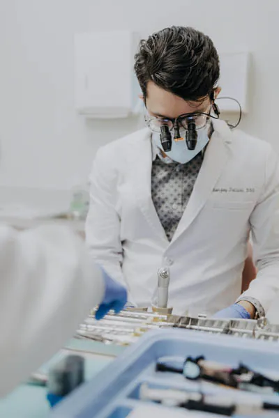 Dr. Talluri gathering his tools to perform a dental checkup on a patient